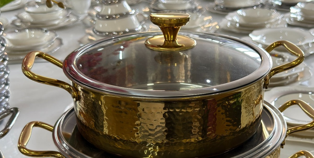 Goldenes Kochtopfset mit Glasdeckel und Metallgriffen